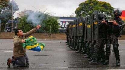 שוטרים מפנים כביש שחסמו תומכי בולסונארו בסאו־פאולו, שלשום. | איי.אף.פי