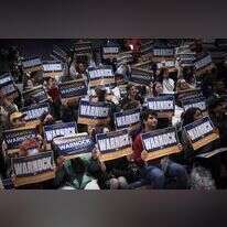 סטודנטים מניפים שלטי תמיכה במועמד הדמוקרטי רפאל וורנוק. | AFP