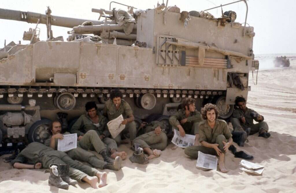 רק מגיבים לתוקפנות המצרית. חיילי צה"ל ממתינים בצל טנק בסיני, 19 באוקטובר 1973. | גטי אימג'ס