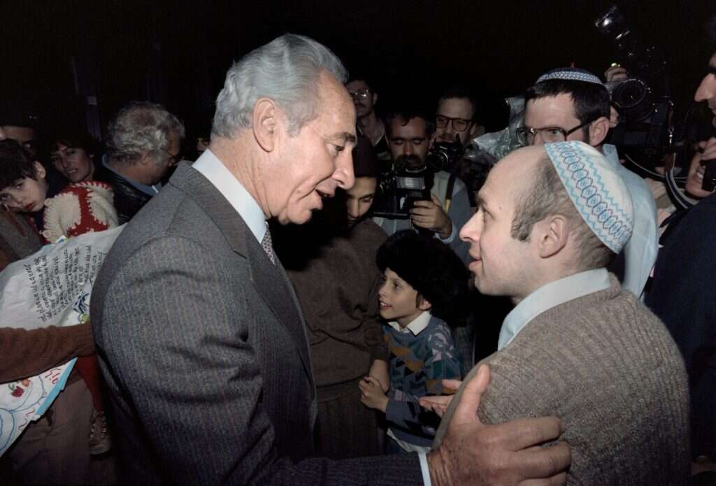 את פניהם קידם בחור צעיר, מזוקן וחובש כיפה: "הלו! הלו! שלום שלום". ראש הממשלה דאז שמעון פרס עם שרנסקי לאחר שחרורו. מעוז מתבונן בפגישה מהצד. | איי.אף.פי