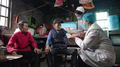 אחיות עורכות בדיקה רפואית בביתם של תושבים בדרום־מערב סין שאינם יכולים לצאת מביתם. | איי.אף.פי