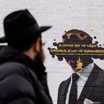 הרב אברהם קגן מביט על ציור הקיר המתוקן. | ג'יימי קלטר דייויס, הוושינגטון פוסט