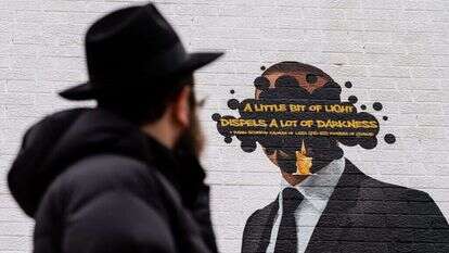 הרב אברהם קגן מביט על ציור הקיר המתוקן. | ג'יימי קלטר דייויס, הוושינגטון פוסט