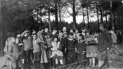 ארתור פיינר, יהודי בן תשעים מניו־יורק, סיפר שעבד בכפר הילדים ונהג לצלם את חיי היומיום. סאלי (קירח, מאחור) עם הילדים. | ארתור פיינר והמחלקה לזכר השואה בתוך ההסתדרות הציונית העולמית, באדיבות החוקרים רוני דותן, טטיאנה מתניה רוגה והבמאי דן וולמן