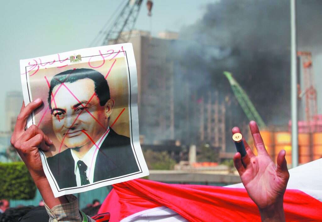 המאבטח המצרי אמר: "אינשאללה מובארק יסיים את תפקידו". שלט בכיכר תחריר, 2011. | גטי אימג'ס