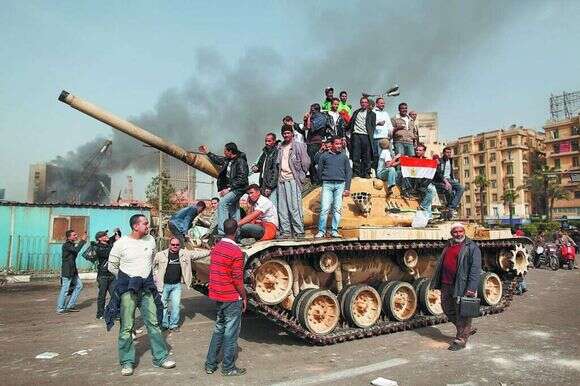 מפגינים על טנק בכיכר תחריר, אוגוסט 2011. | גטי אימג'ס מפגינים על טנק בכיכר תחריר, אוגוסט 2011. | גטי אימג'ס