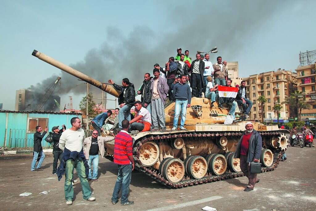 האלימות דוכאה באמצעות הטלת פחד. מפגינים על טנק בכיכר תחריר, אוגוסט 2011. | גטי אימג'ס