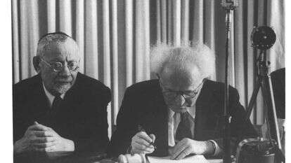 הרב מימון לצידו של דוד בן גוריון בחתימה על מגילת העצמאות. | הנס פין, לע"מ הרב מימון לצידו של דוד בן גוריון בחתימה על מגילת העצמאות. | הנס פין, לע"מ