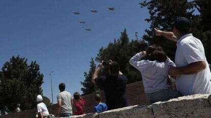 אזרחים צופים במטס ביום העצמאות. | EPA