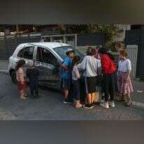 ילדים ליד רכב שנפגע מהרקטות שנורו לעבר שדרות בשבוע שעבר. | AFP