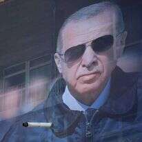 נער טורקי עומד ליד שלט בחירות של ארדואן. | EPA