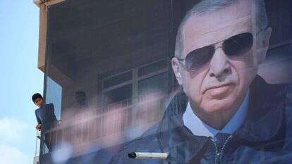 נער טורקי עומד ליד שלט בחירות של ארדואן. | EPA