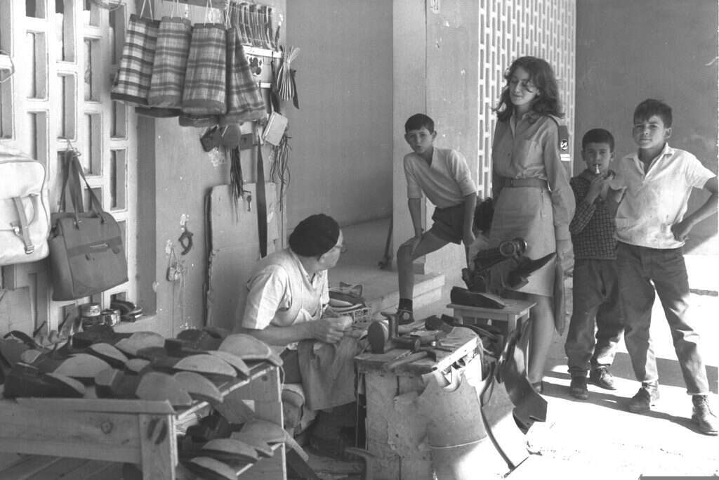 התושבים בעיירות הגיעו מהאונייה לכפר, ולא ממש פגשו את ישראל הראשונה לפני שהגיעו לביתם החדש. סנדלר בשדרות, 1965. | משה פרידן, לע"מ