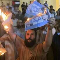 מפגינים בלוב מציתים דף עם דגל ישראל ותמונותיהם של שר החוץ הישראלי אלי כהן ושרת החוץ הלובית. | Yousef Murad, AP