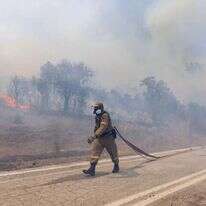 לוחם אש נלחם בשריפות המשתוללות ביוון. | Achilleas Chiras, AP