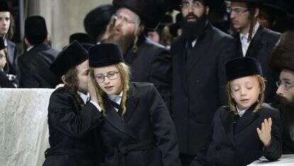 מסורת חדשה ישנה. ילדים חסידיים חובשים קסקט. | שאטרסטוק