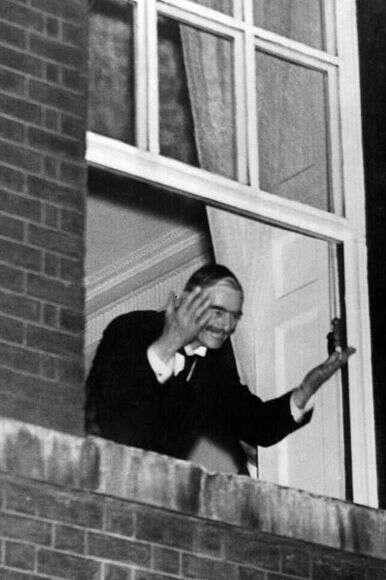 צ'מברליין מנופף לקהל מחלון המעון בדאונינג 10 לאחר החתימה על הסכם מינכן. | גטי אימג'ס