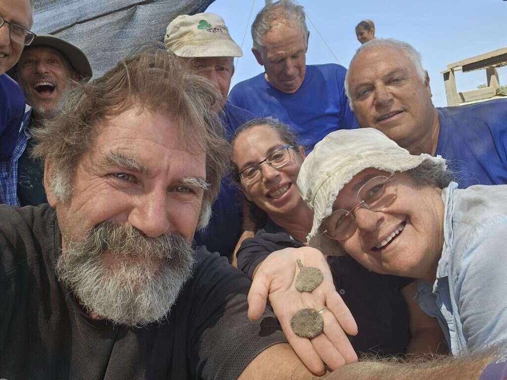 פעילות באושה העתיקה. מתנדבים מחזיקים מטבע ותליון שמצאו. | רשות העתיקות