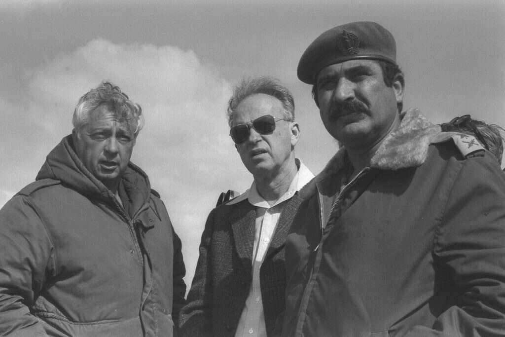 במרכז ראש הממשלה יצחק רבין ומשמאל יועצו לענייני ביטחון אריאל שרון. מימין קותי אדם בסיני ב־1976. | משה מילנר, לע"מ