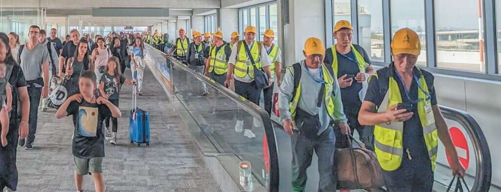 הלבוש בטיסה מבהיר מיד שזוהי קבוצת פועלים. המסדרון בנתב"ג אחרי נחיתת הטיסה מהונג־קונג. | יש פלג