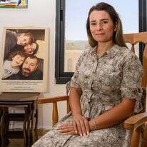 "את הדאגות השארתי אצלי". נאהד ח'יר א־ דין בביתה, על רקע תמונה משפחתית עם מחמוד והילדים. | אייל מרגולין, ג'יני