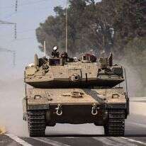 טנק נוסע על הכביש ליד העיר שדרות לכיוון גבול רצועת עזה. | AFP