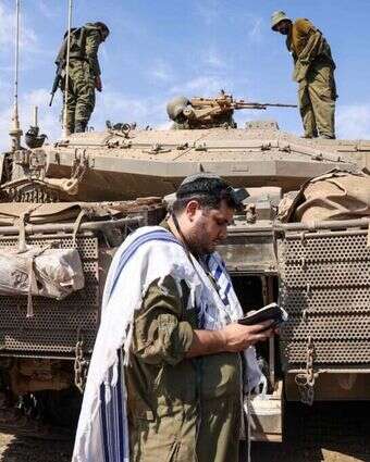 לוחם מתפלל ליד טנק בגבול הצפון, אוקטובר 2023 | AFP לוחם מתפלל ליד טנק בגבול הצפון, אוקטובר 2023 | AFP