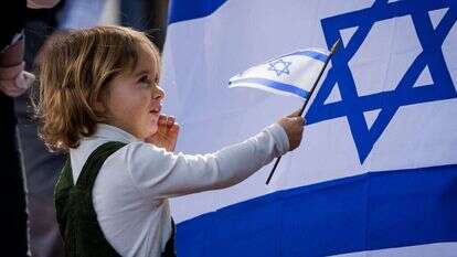 ילדה מנופפת בדגל מול שגרירות ישראל בוושינגטון. | גטי אימג'ס