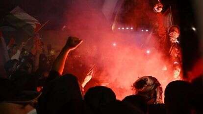 רעולי פנים משלהבים את הקהל. | EPA