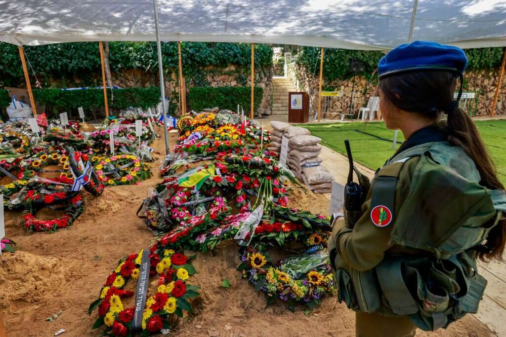 חיילת שומרת על קבריהם הטריים של חללי צה"ל שנהרגו במלחמה מול חמאס, בית הקברות הצבאי הר הרצל בירושלים. | יוסי זמיר פלאש 90