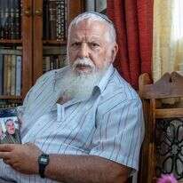 הרב בני קלמנזון עם תמונת בנו אלחנן ז"ל. | יוסי אלוני