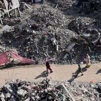 פלסטינים הולכים ברחוב הרוס בעזה, אתמול. | AFP