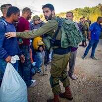 לוחם מאבטח כניסת פועלים פלסטינים למסיק. | נאסר אישתיאה, פלאש 90