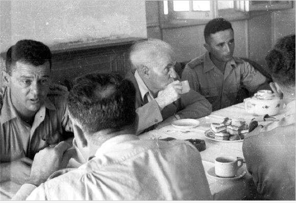 "ככל אשר ירבה מספר המתיישבים עזי־הרוח על הגבולות, יגדל ביטחון ישראל". בן־ גוריון עם קציני צה"ל, 1948. | ארכיון דן הדני, האוסף הלאומי לתצלומים ע"ש משפ' פריצקר, הספריה הלאומית,