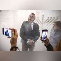 גז'גורז בראון לאחר שכיבה את החנוכייה בבניין הפרלמנט הפולני עם מטף. | Beata Zawrzel/NurPhoto via Getty Images