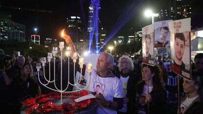 מפוני קיבוץ בארי ומשפחות חטופים בהדלקת נר חנוכה מול הקריה בתל־אביב. | אי.פי.איי