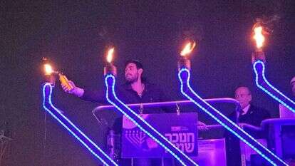 חגי אנלגמן, בנו של מבקר המדינה מתניהו אנגלמן, שנפצע בקרבות בעזה, מדליק נרות חנוכה בירושלים