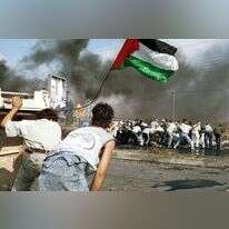 פלסטינים מניפים את דגל אש"ף במהלך עימותים בצפון רמאללה במהלך האינתיפאדה השנייה. | יולה מונקוב - פלאש 90