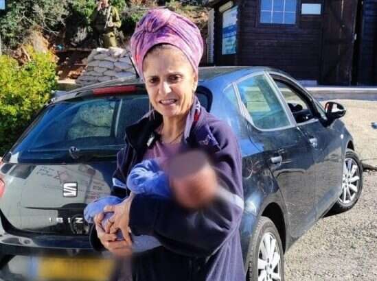 חובשת מד"א אורלי שלמה עם התינוק שהיה ברכב וניצל מפיגוע הירי סמוך לעטרת. | דוברות מד"א