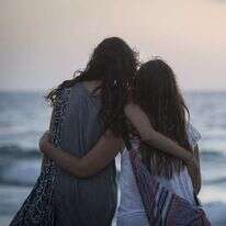 נערות מתחבקות מול שקיעה בחוף הים בתל אביב. | הדס פרוש, פלאש90