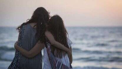 נערות מתחבקות מול שקיעה בחוף הים בתל אביב. | הדס פרוש, פלאש90