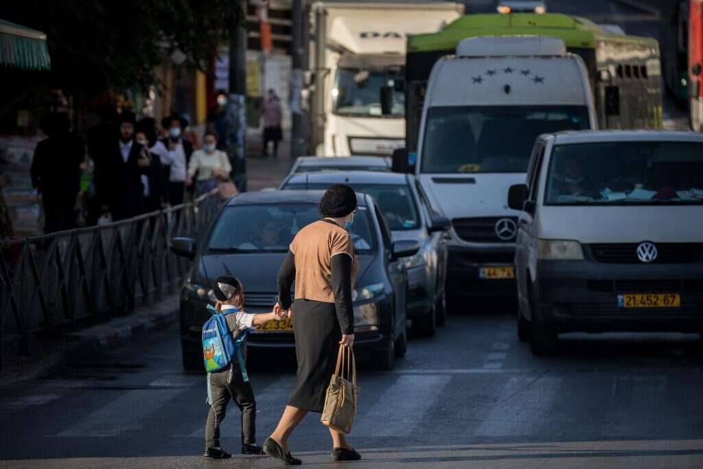 אישה חרדית מטיילת עם בנה בצומת בר-אילן בירושלים. | יונתן זינדל, פלאש90