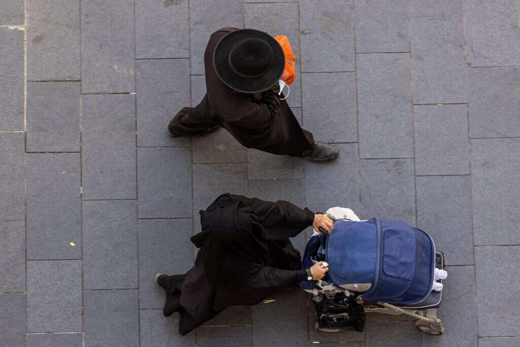 אישה מכוסה מכף רגל ועד ראש, הידועה כאשת טליבאן וגבר יהודי חרדי מטיילת בירושלים. | יונתן סינדל, פלאש 90