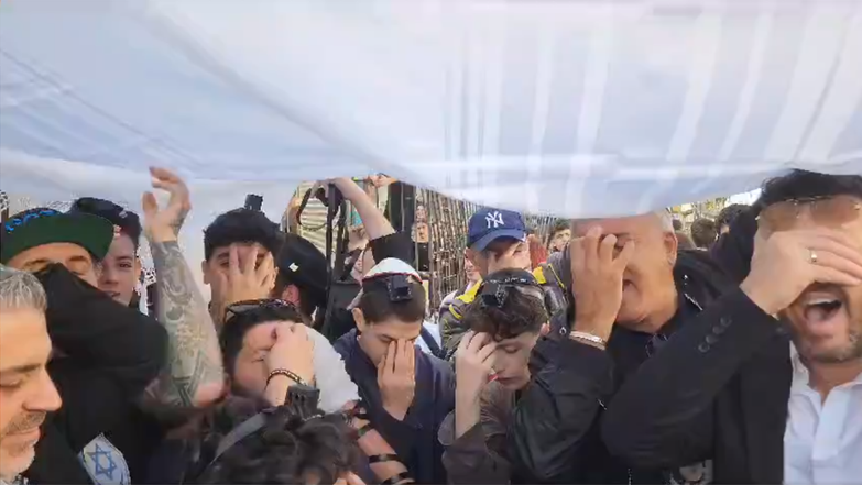 תלמידי "גימנסיה הרצליה" ומפגינים נוספים מניחים תפילין וקוראים קריאת שמע מחוץ לבית הספר. | מסך מתוך סרטון ב-X (טוויטר)