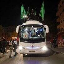 אוטובוס של הצלב האדום עם דגלי חמאס, שבו מחבלים ששוחררו מהכלא הישראלי במסגרת עסקת החטופים הראשונה. | EPA