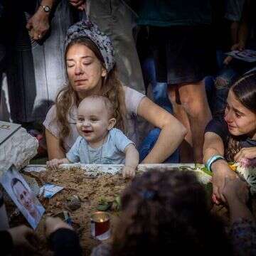 ענת מאיר, אלמנתו של דוד מאיר שנפל בשביעי באוקטובר, יחד עם בנם התינוק מתאבלת על קברו. | חיים גולדברג - פלאש 90