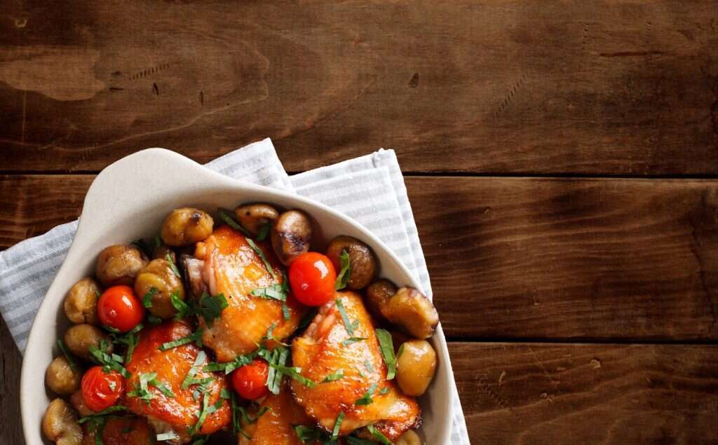 שוקי עוף וערמונים בסיר אחד. | שאטרסטוק