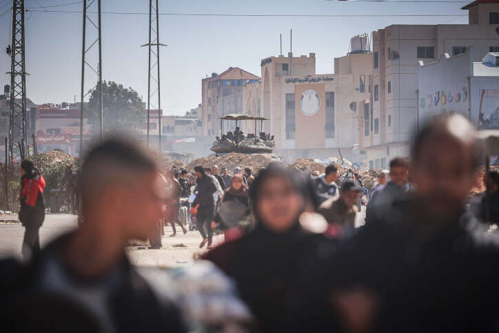 טנקים ישראליים מאבטחים את אזור חאן יונס, בזמן שאזרחים פלסטיניים יוצאים מהעיר. | אטיה מוחמד, פלאש 90