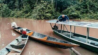 פועל מתקין גגון סולארי על סירת נהר. | Misha Vallejo Prut for The Washington Post