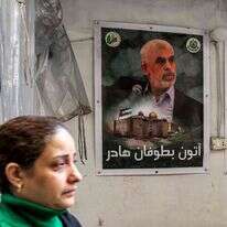 כרזות של סנוואר ואל עוביידה תלויות על קיר במחנה פליטים הפלסטיני בלבנון. | AFP